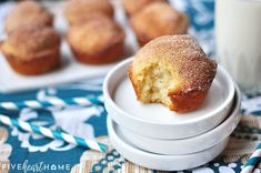 a muffin sitting on top of a white plate next to a glass of milk