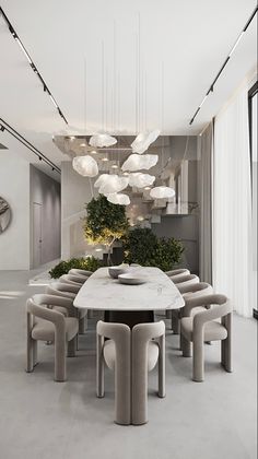 an elegant dining room with modern lighting fixtures and large table surrounded by chairs, plants and potted trees