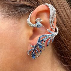 Make A Statement With This Ear Jacket. The Peacock Design Will Definitively Make Your Look Fashionable. The Bottom Of This Ear Wrap Requires Your Ear To Be Pierced But The Top Can Easily Slide On Your Ear. This Is A Single Ear Jacket, It Is Sold As 1 Unit And Doesn't Come As A Pair. This Ear Jacket Can Be Worn Only On The Right Or Left Ear. Material: Sterling Silver Stones: Micro Paved White Simulated Diamonds And Lab Created Emeralds Color: Silver Size Of Earring: Large (Length: 6.5 Cm / 2.5 In Hamsa Earrings, Peacock Earrings, Fancy Jewellery Designs, Purple Diamond, Mini Earrings, The Peacock, Feather Jewelry, Ear Jacket, Peacock Design