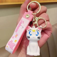 a person holding a keychain with a cat on it's side and an eraser in the other hand