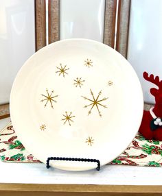 a white plate sitting on top of a table next to a red reindeer toy and christmas decorations