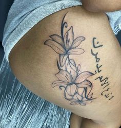 a woman's thigh with flowers on it and the word love written in arabic