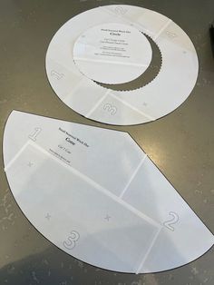 two pieces of paper cut out to look like circular discs with numbers on each side