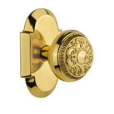 an ornate brass door knob with a decorative design on the front and side, set in polished brass