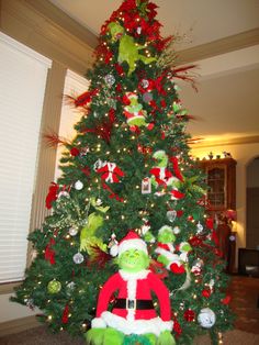 there is a christmas tree decorated with green and red decorations, including the grinch