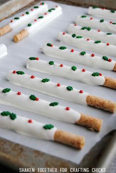 some crackers with white icing and green sprinkles are on a baking sheet