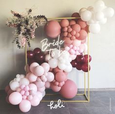 the balloon arch is decorated with pink and white balloons