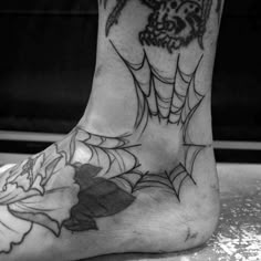 a black and white photo of a person's foot with tattoos on it