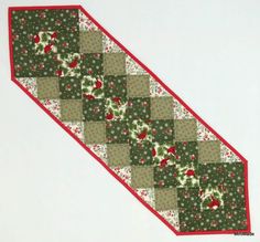 a close up of a patchwork piece of fabric with red and green flowers on it