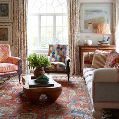 a living room filled with lots of furniture and decor on top of a colorful rug