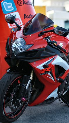 a red and white motorcycle parked next to a bus