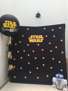 a star wars themed birthday party with balloons and decorations on the wall, including a droid balloon