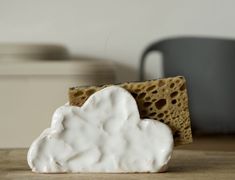 a piece of bread with a white cloud on it sitting on top of a wooden table