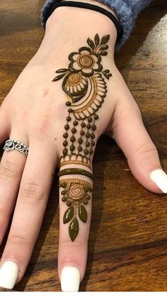 a woman's hand with henna tattoos on it