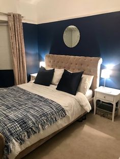 a bedroom with blue walls and white bedding