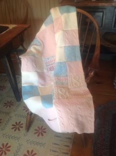 a pink blanket sitting on top of a wooden chair