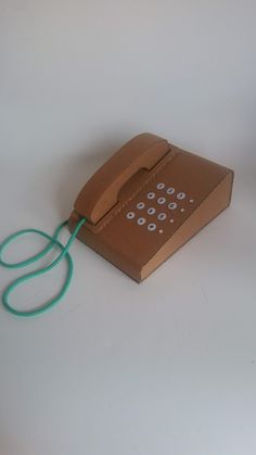 a brown box with a green cord attached to it and a computer mouse in the middle