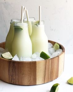 three glasses of limeade on ice in a wooden tray