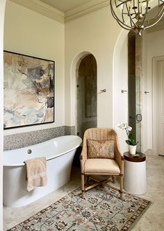 a bath room with a tub a chair and a painting on the wall next to it