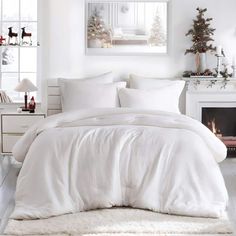 a bedroom with white bedding and christmas decorations