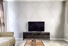 a living room with a couch, coffee table and television on top of the tv stand