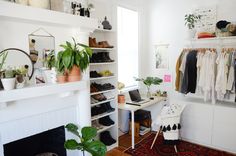 a white room with lots of clothes and plants