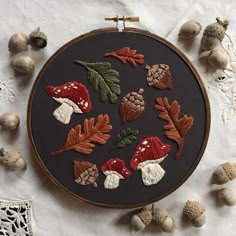 an embroidery project with mushrooms and acorns