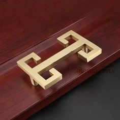 a wooden table with a metal object on top of it and a black surface in the background