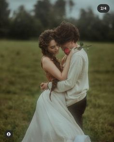 a young man and woman embracing in a field