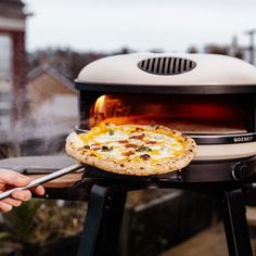 a pizza is being cooked on an outdoor grill