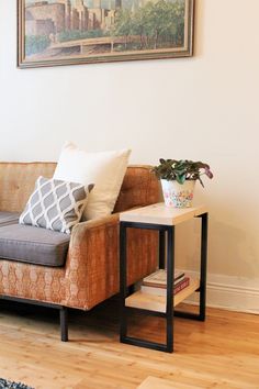 a living room with a couch, coffee table and painting on the wall above it