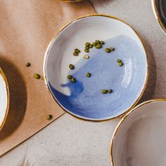 there are many bowls and plates on the table with food in them, including peas