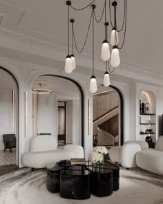 a living room filled with white furniture and lots of lights hanging from the ceiling above