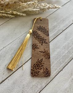 a wooden bookmark with a tassel hanging from it's side on a table