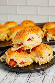 two black plates filled with cheesy pizza sliders