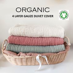 four folded towels in a wicker basket with text organic 4 layer gauze duvet cover