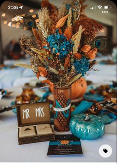 a vase filled with lots of colorful flowers next to a couple's initials on a table