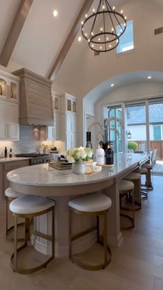 a large kitchen with an island in the middle and two stools at the end