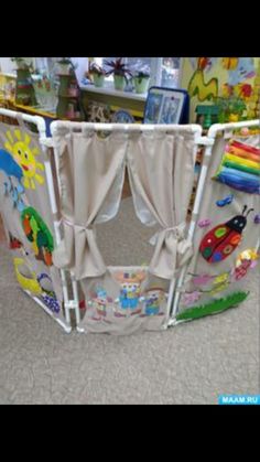 a child's playpen with curtains and toys on the floor