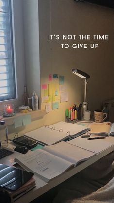 an office desk with a laptop computer on it and a note pad next to it