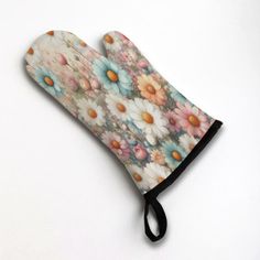 an oven mitt with flowers on it sitting on top of a white countertop