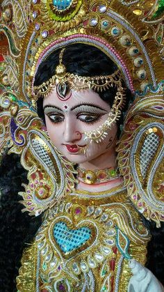 a close up of a woman's face with gold and jewels on her head