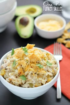 a white bowl filled with rice next to an avocado