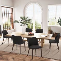 a dining room table with black chairs and a fire place in the corner next to it