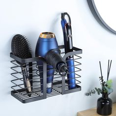 a hair dryer, combs and other items are on a metal shelf next to a mirror