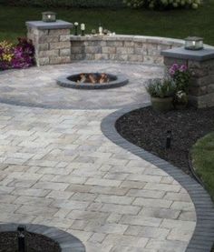 an outdoor fire pit surrounded by landscaping