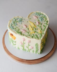 a heart shaped cake sitting on top of a white plate next to a wooden platter