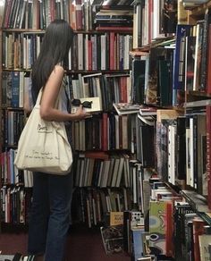 a woman standing in front of a book shelf filled with books