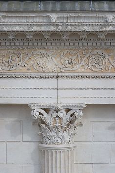 the corner of an old building with a clock on it's face and columns