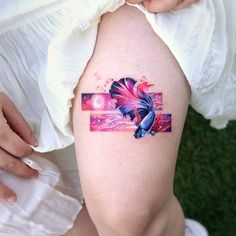 a woman's thigh with a tattoo on it that has an image of a fish